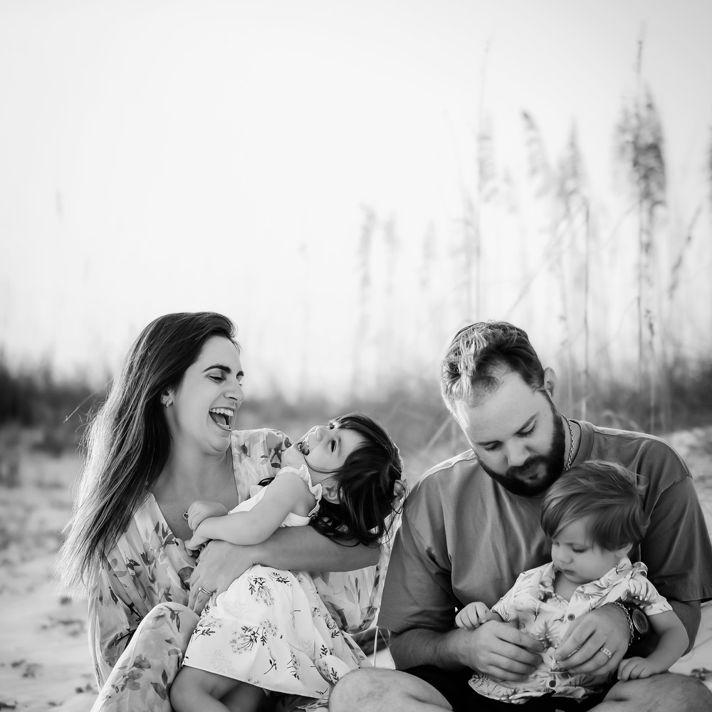 Luiza and her husband laughing with their kids on the beach